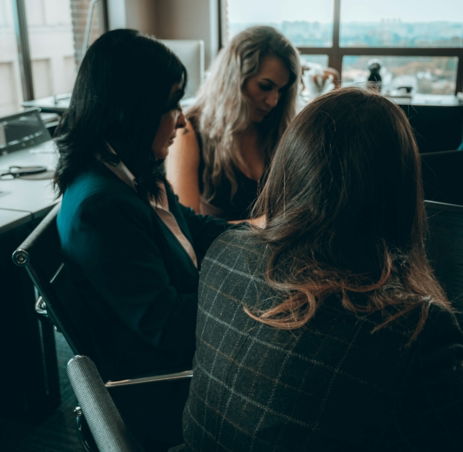 a group of women sitting around each other in a room